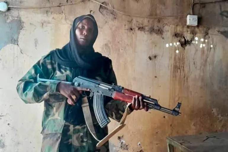 Combattante Sara Ismaïl, vêtue d’un uniforme militaire et portant un fusil Kalachnikov au sein du Mouvement de libération du Soudan (MLS) dirigé par Minni Arko Minnawi.